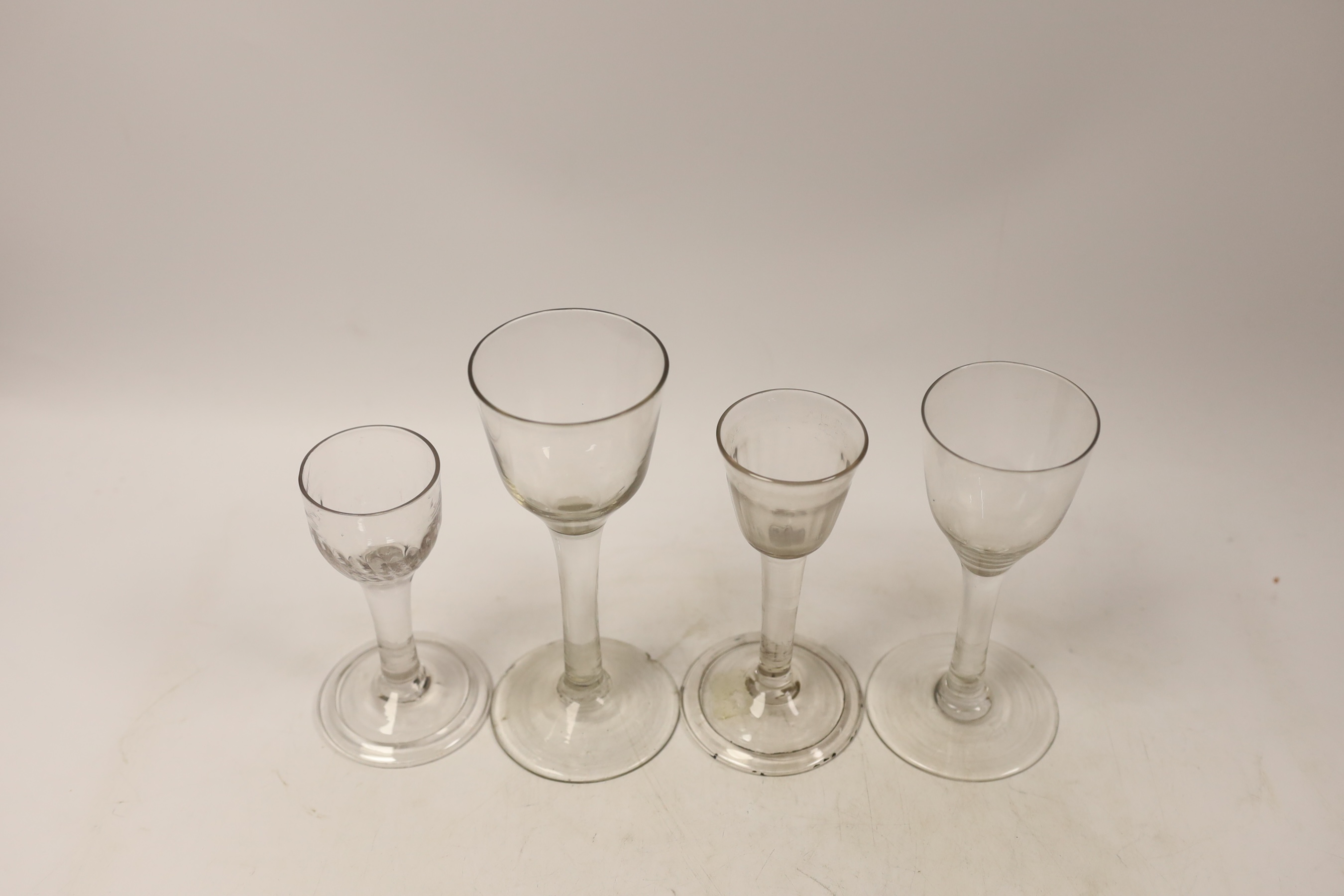 Four plain stem wine and cordial glasses, first half 18th century, two examples with folded feet, tallest 16.5cm